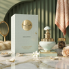Uno scatto di lusso del flacone Juman Exclusive da 100 ml e della confezione regalo, su una superficie di marmo con perle, petali di rosa e accenti decorativi.